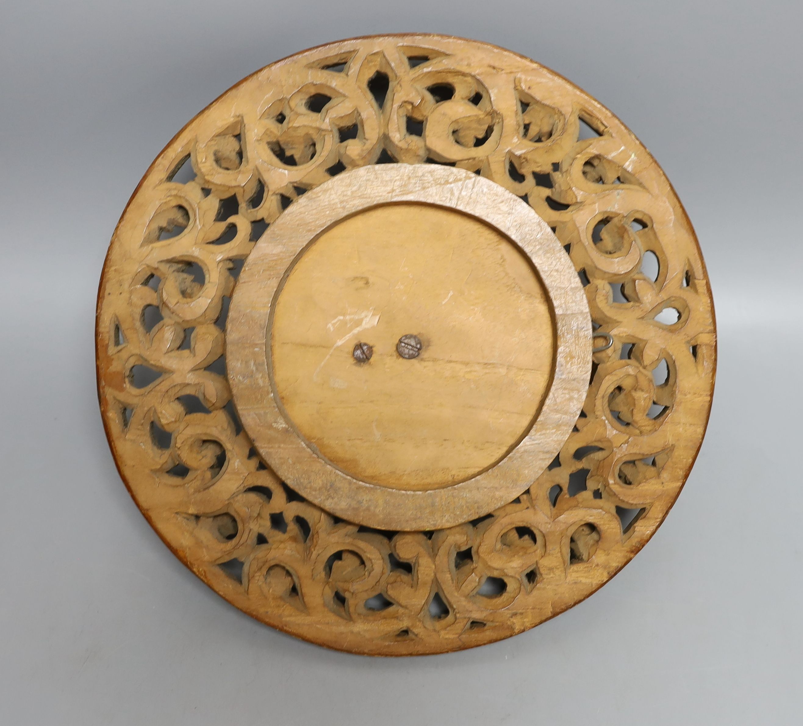 A Chinese blue and white plate with floral decoration, 23cm diameter, together with another plate and wooden panel relief of oriental figure (3)